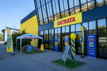 Facciata di un punto vendita Risparmio Casa con insegna Entrata, gazebo promozionale e cartellonistica pubblicitaria.