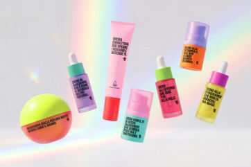 Prodotti skincare Pinalli: crema correttiva, sieri viso e maschera al mango su sfondo arcobaleno colorato