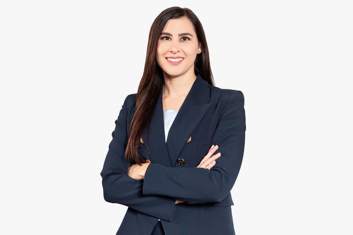 Sara Lupi, nuovo volto Luxury Beiersdorf, in blazer blu a braccia conserte su sfondo bianco