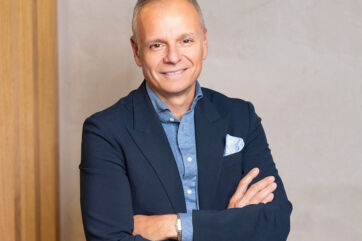 Ritratto di Jean-Marc Bellaiche, nuovo CEO del Douglas Group, in giacca blu con braccia conserte