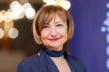 Ritratto di Lucia Tagliaferri, nuova Direttrice Generale di Coop Italia, con capelli biondi e rossetto rosso.
