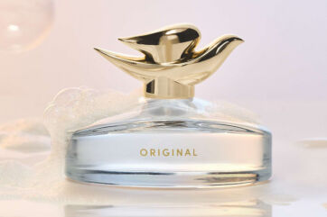 Flacone di profumo Dove Original Fragrance con tappo dorato a forma di uccello, nella profumeria premium.